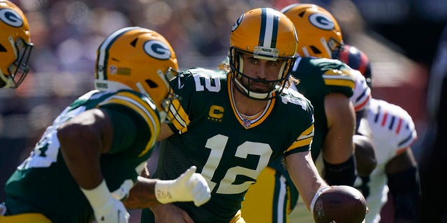 O quarterback do Green Bay Packers Aaron Rodgers (12) devolve a bola para AJ Dillon durante o primeiro tempo de um jogo de futebol da NFL no domingo, 17 de outubro de 2021, em Chicago.