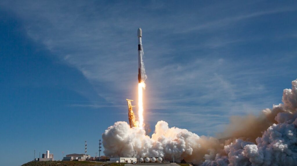 a white and black spacex falcon 9 rocket launches into a blue sky