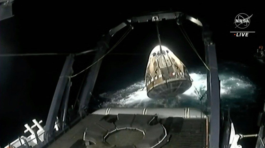 Esta captura de tela da transmissão ao vivo da NASA mostra a espaçonave SpaceX Crew Dragon Endeavour sendo elevada para uma nave de recuperação após cair na costa de Jacksonville em 4 de setembro de 2023. 