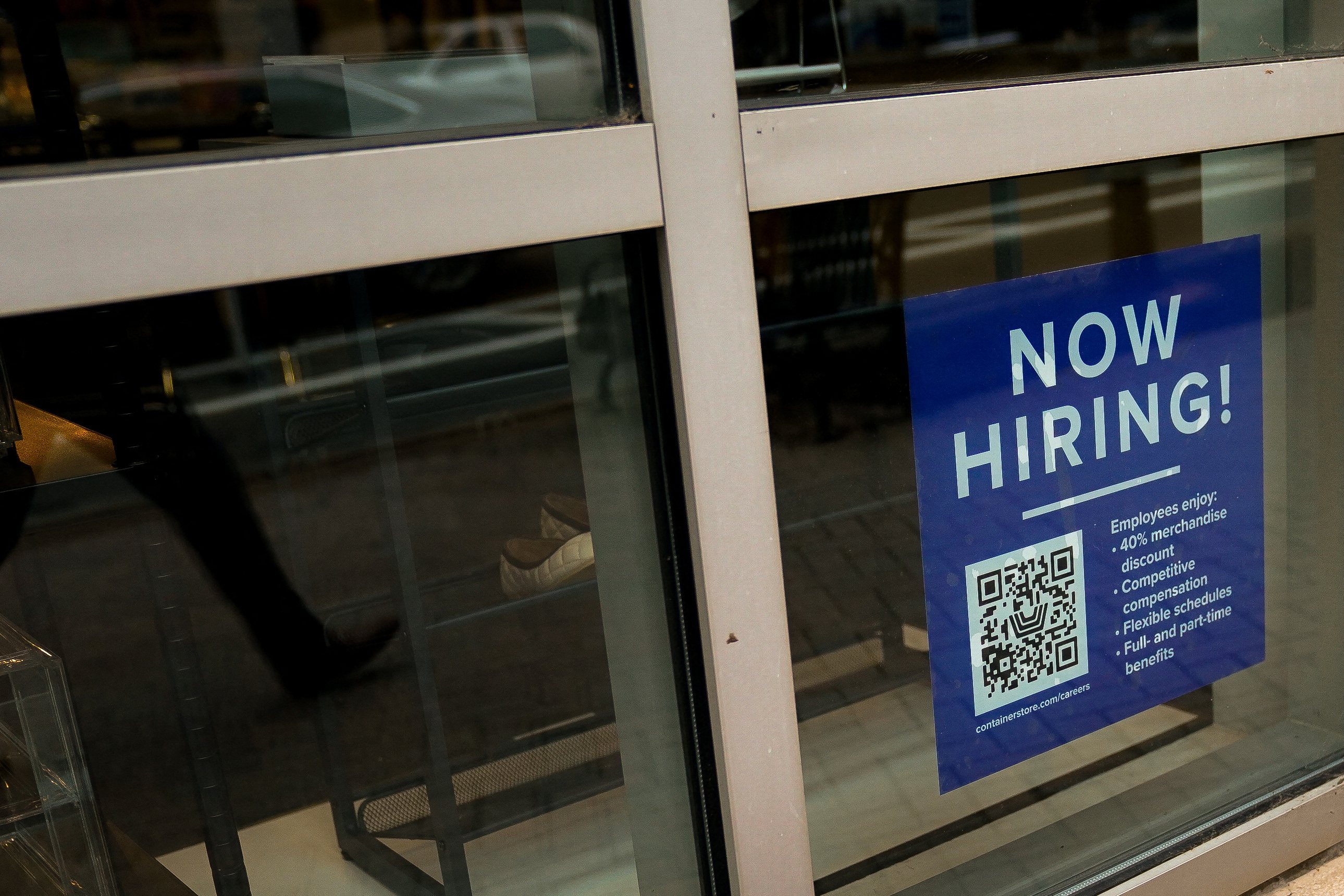 Uma placa de emprego de funcionário com um código QR aparece na vitrine de uma empresa em Arlington