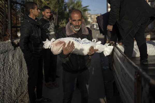 Um palestino carrega o corpo de seu neto, que foi martirizado no bombardeio israelense à Faixa de Gaza, no Hospital Rafah, ao sul de Gaza, sexta-feira, 22 de dezembro de 2023. (AP Photo/Fatima Shbair)