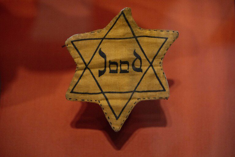 Distintivo de estrela de David com palavra holandesa "qualidade"ou "O judeu"usado durante a Segunda Guerra Mundial, está em exibição no novo Museu Nacional do Holocausto em Amsterdã, Holanda, terça-feira, 5 de março de 2024. (AP Photo/Peter Dejong)