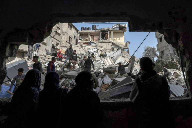 Palestinians check the rubble of buildings that were destroyed following overnight Israeli bombardment in Rafah, in the southern Gaza Strip (MOHAMMED ABED)