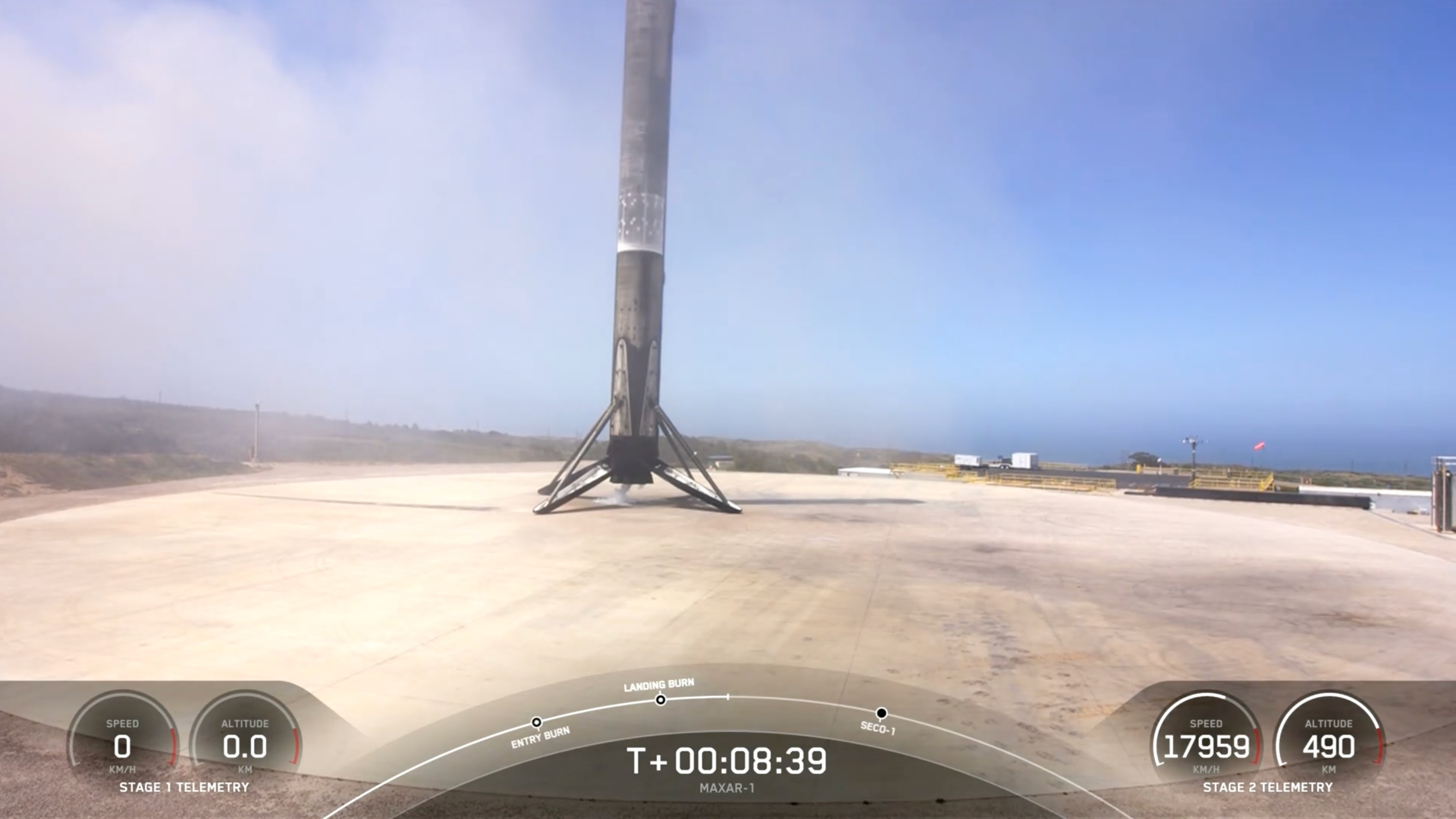 O primeiro estágio de um foguete SpaceX Falcon 9 preto e branco é colocado na plataforma de pouso logo após o pouso.